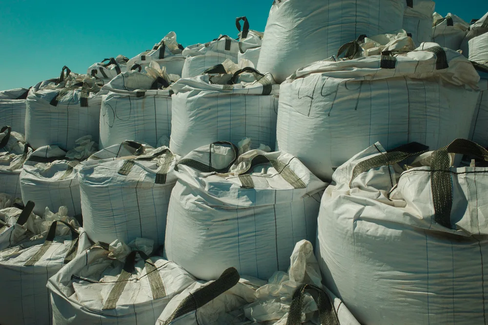 Stacked woven polypropylene bulk bags against open sky